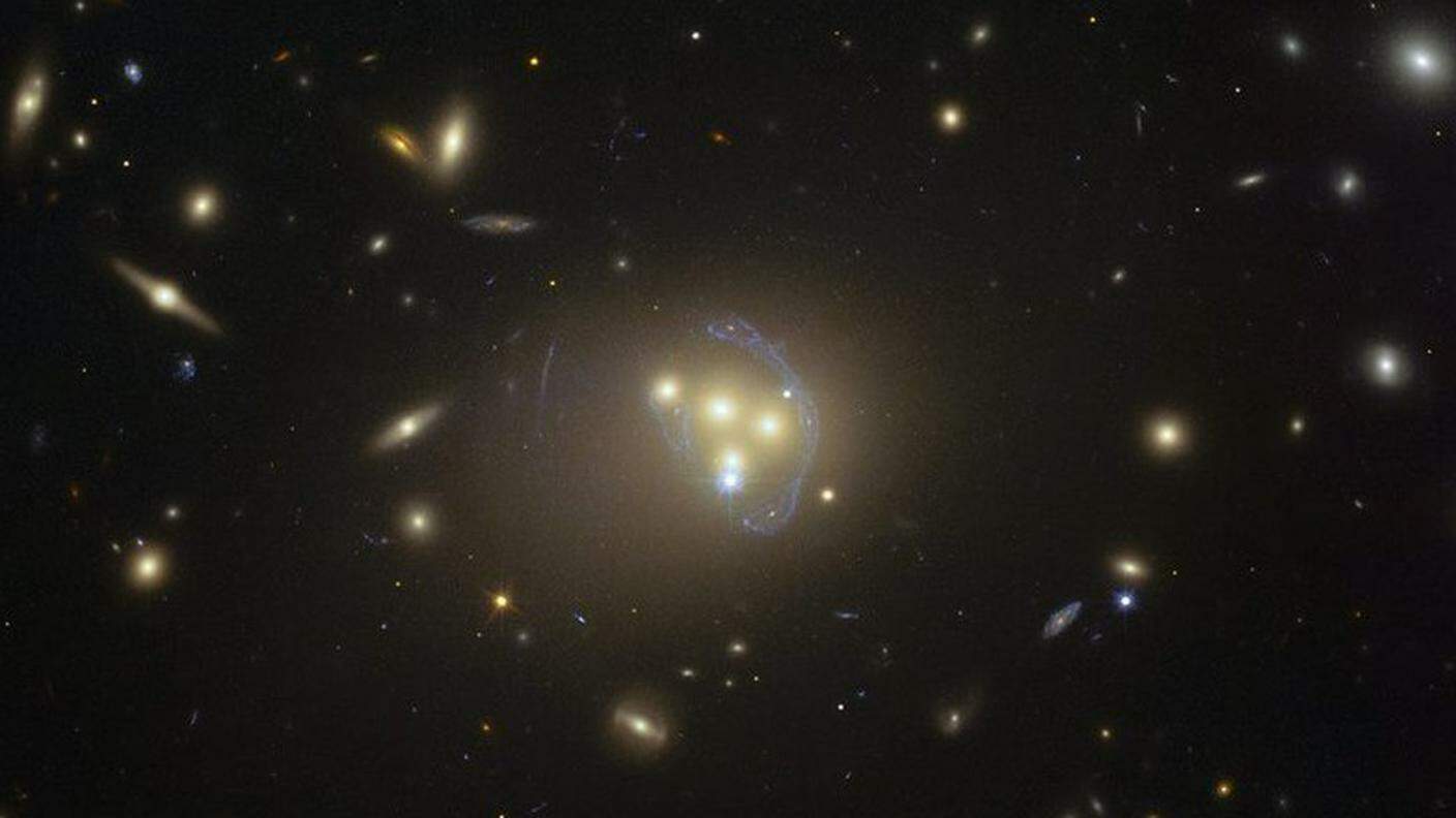 Al centro l'ammasso di galassie in questione in un immagine di Hubble