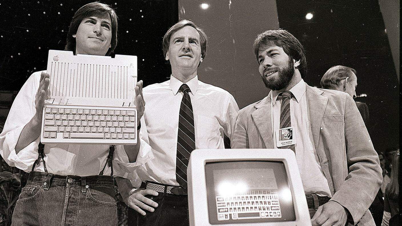 April 1984. Steve Jobs (a sinistra) John Sculley (al centro) e Steve Wozniak con il nuovo Apple IIc a San Francisco