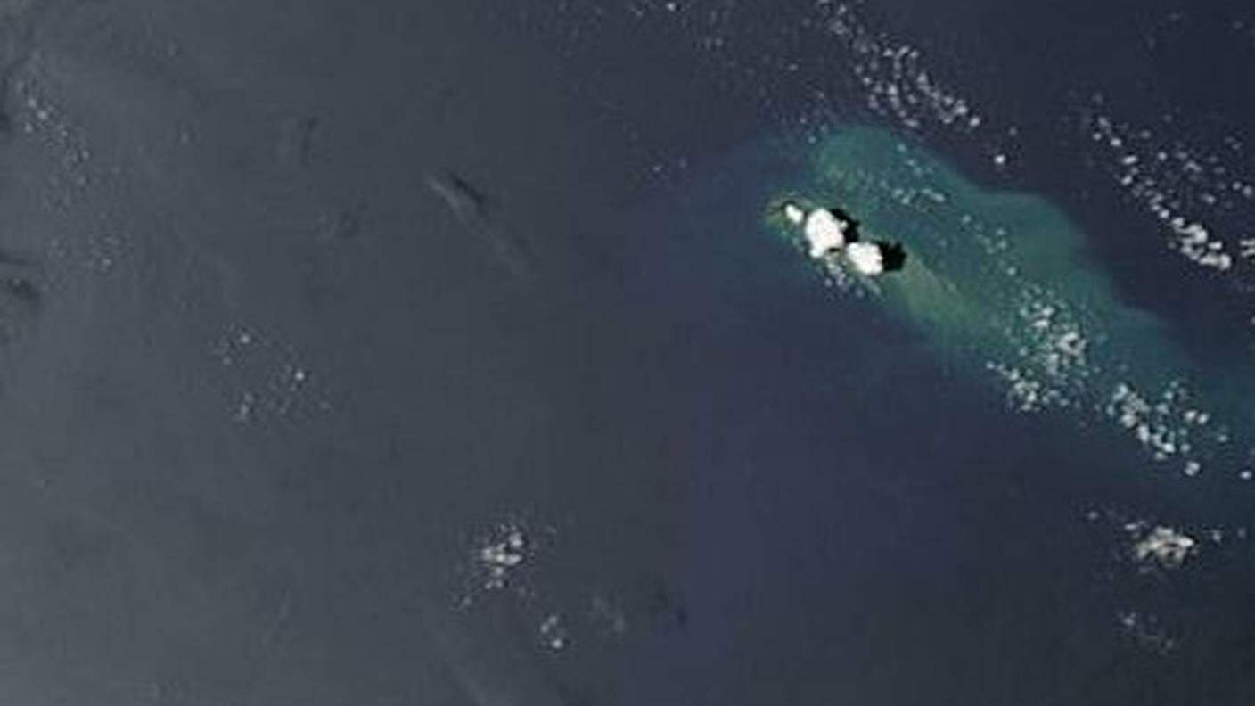 Due nuvolette bianche indicano l'eruzione in atto a Tonga
