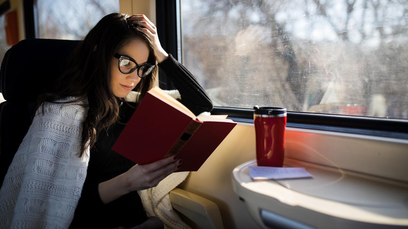 Donna che legge mentre viaggia