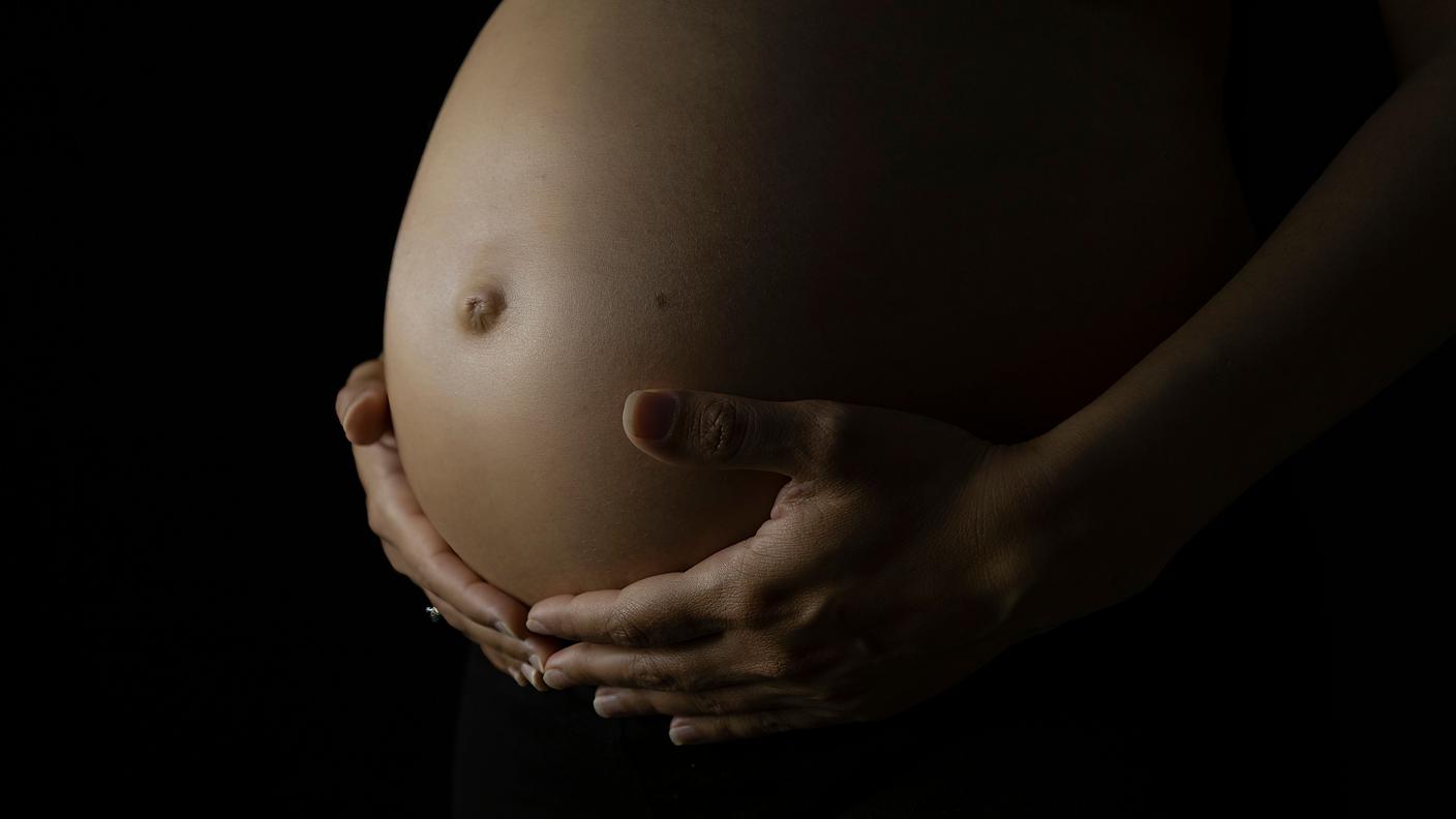 Close-up of pregnant belly cradled by hands.jpg