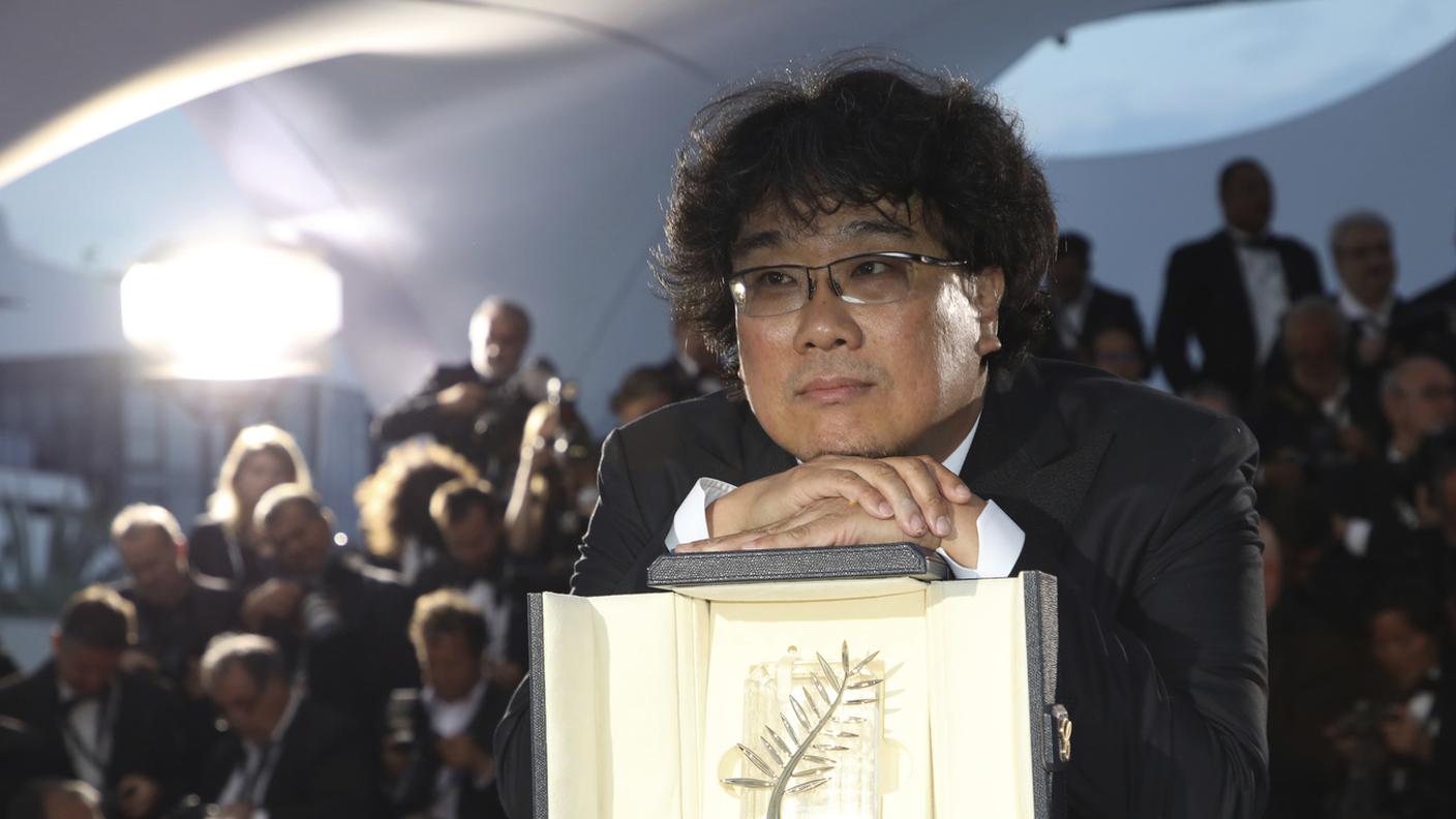 Il regista Bong Joon-ho posa con il premio Palme d'Or per il film "Parasite"