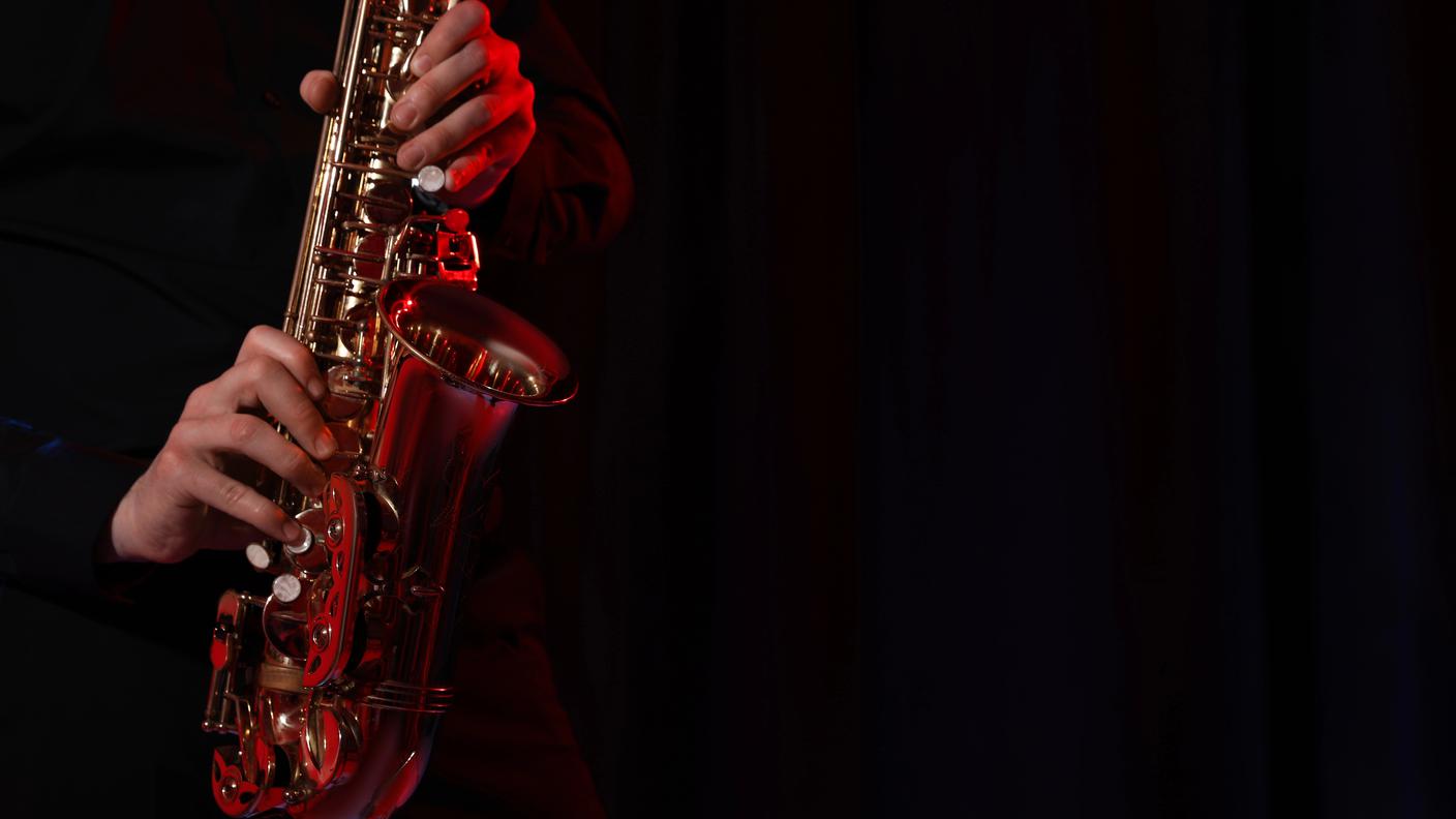 Man with saxophone on dark background