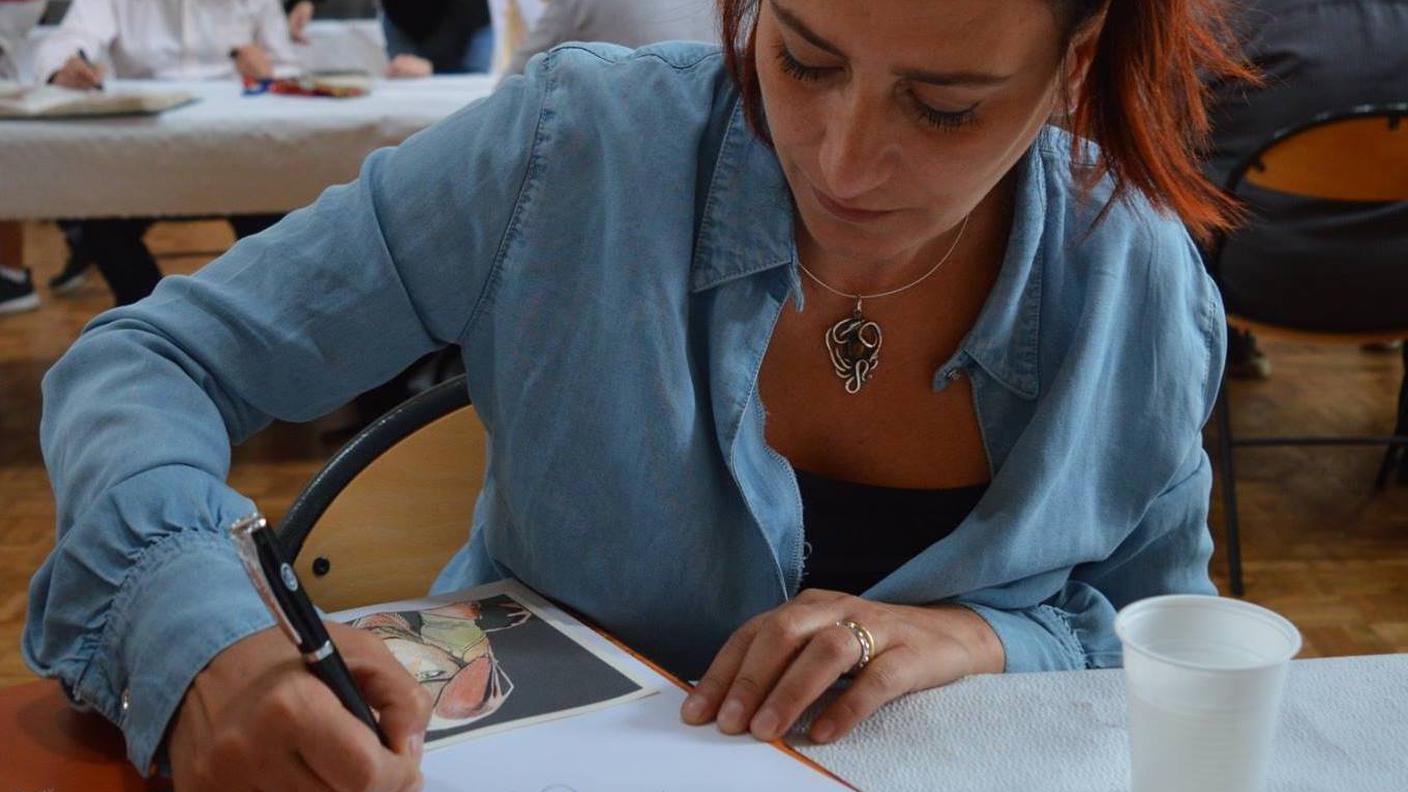 Simona Mogavino mentre firma uno dei suoi disegni