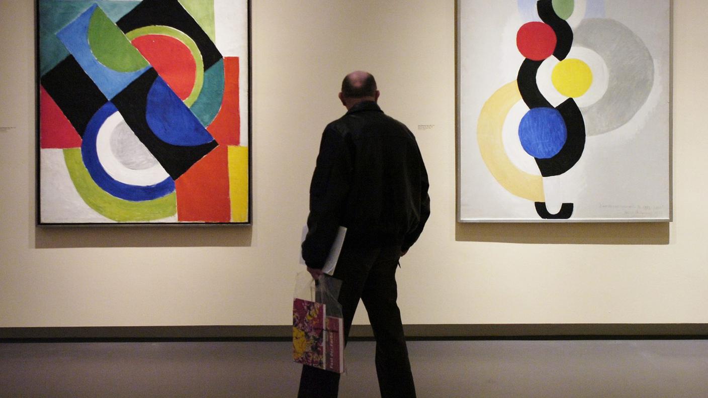 Un visitatore della Kunsthaus di Zurigo osserva i dipinti "Colour Rhythm", a sinistra, e "Endless Rhythm, Dance" dell'artista russo-francese Sonia Delaunay-Terk