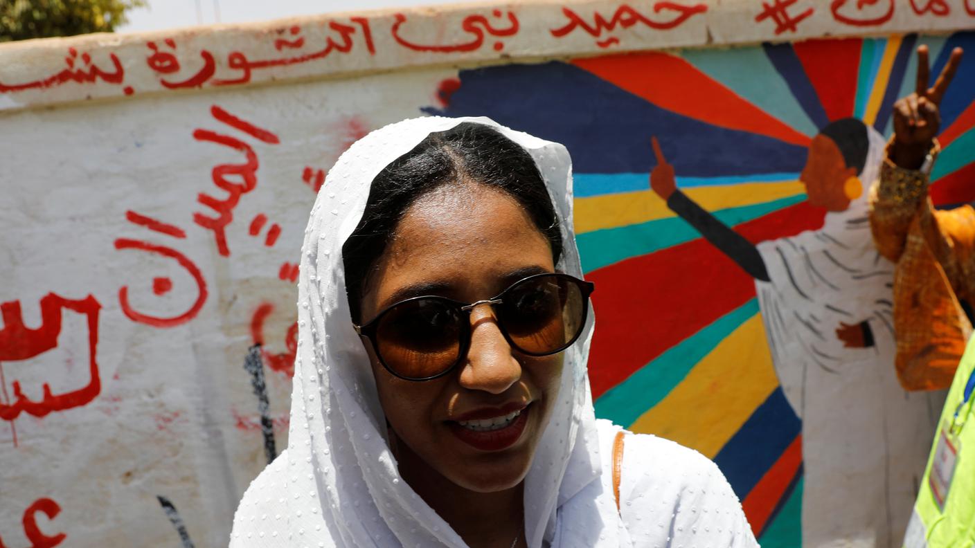 Alaa Salah, una contestatrice sudanese il cui video è diventato virale e ne fa un'icona per le proteste antigovernative di massa, si trova di fronte a un murale che la ritrae davanti al Ministero della Difesa di Khartoum.