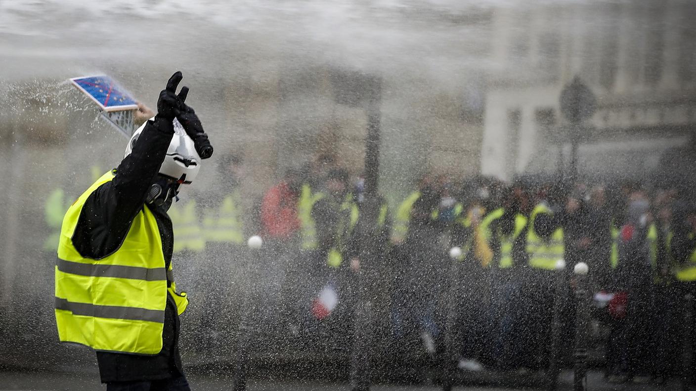 Alcuni gilet gialli sotto gli idranti delle forze dell'ordine francesi