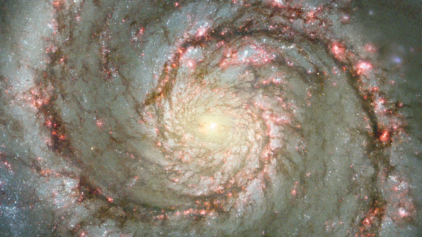 Un dettaglio della Galassia Vortice che mostra addossate ai bracci di spirale diverse nubi interstellari, tra cui varie regioni H II (in rosato) e nubi di polveri oscure, luoghi d'elezione dei processi di formazione stellare. HST - NASA/ESA