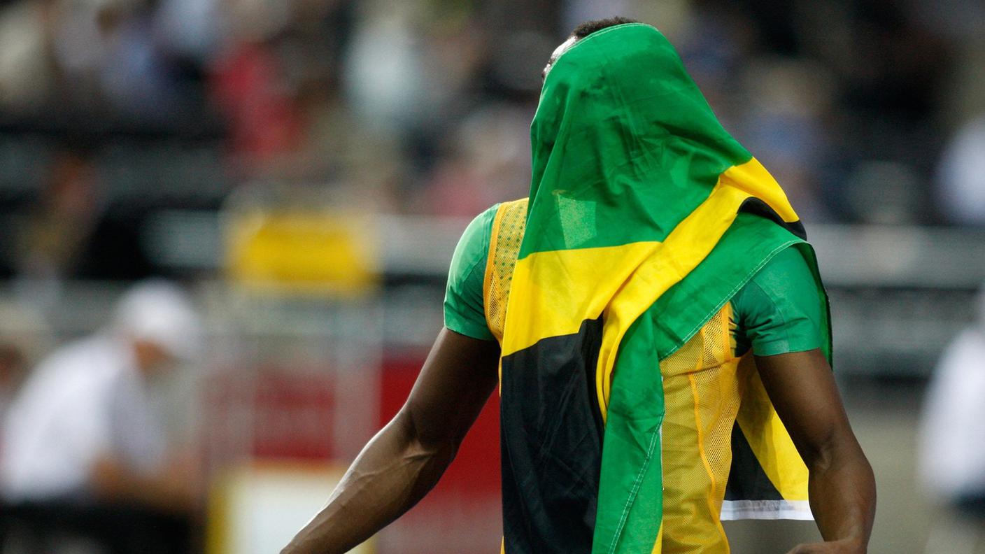 Usain Bolt con la bandiera giamaicana
