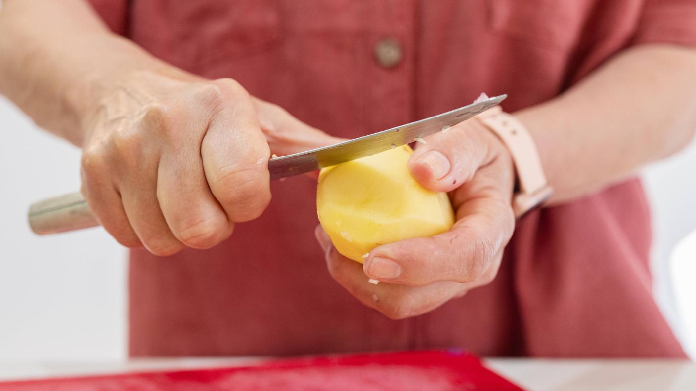 elderly woman peeling a potato.jpg