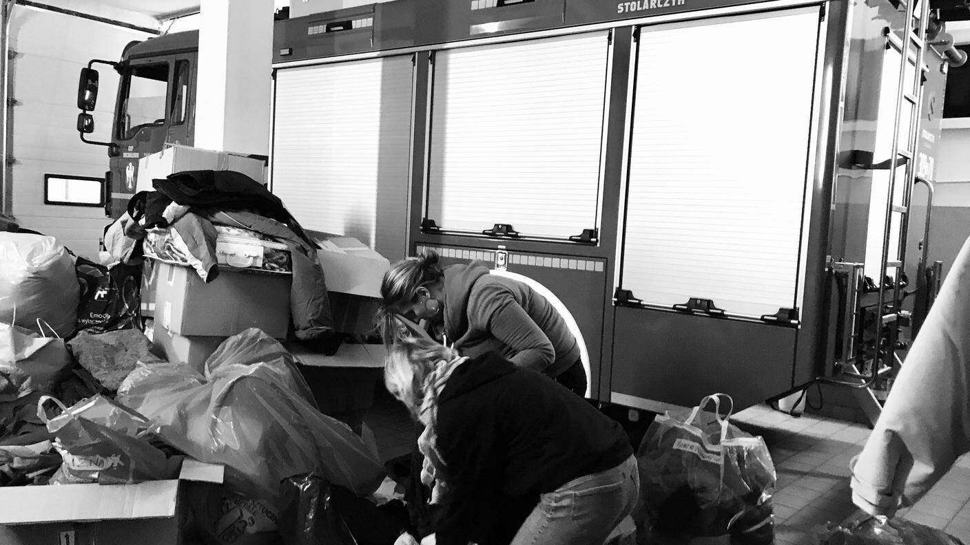 Volontari nella caserma dei pompieri di Michalowo, trasformata in centro di raccolta per l’assistenza ai migranti.jpg