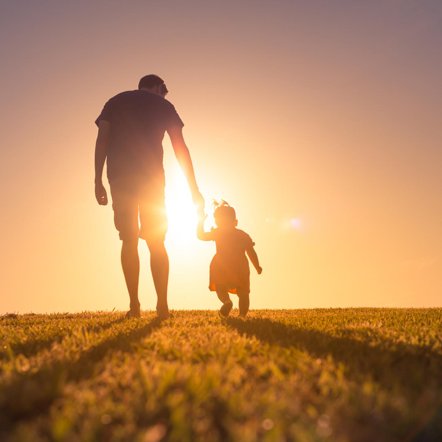 papà, padre e figlia che si tengono per mano e camminano al tramonto all'aperto