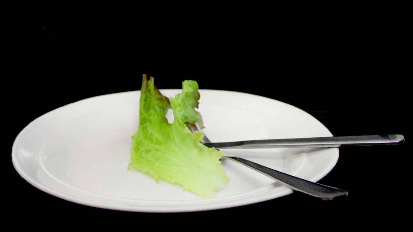Concetto dieting, mangiare vegetariano o Disturbo alimentare. Lattuga sul piatto