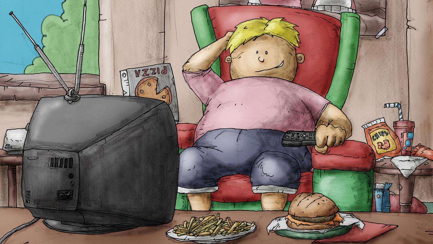 Bambino sovrappeso mentre guardando la televisione