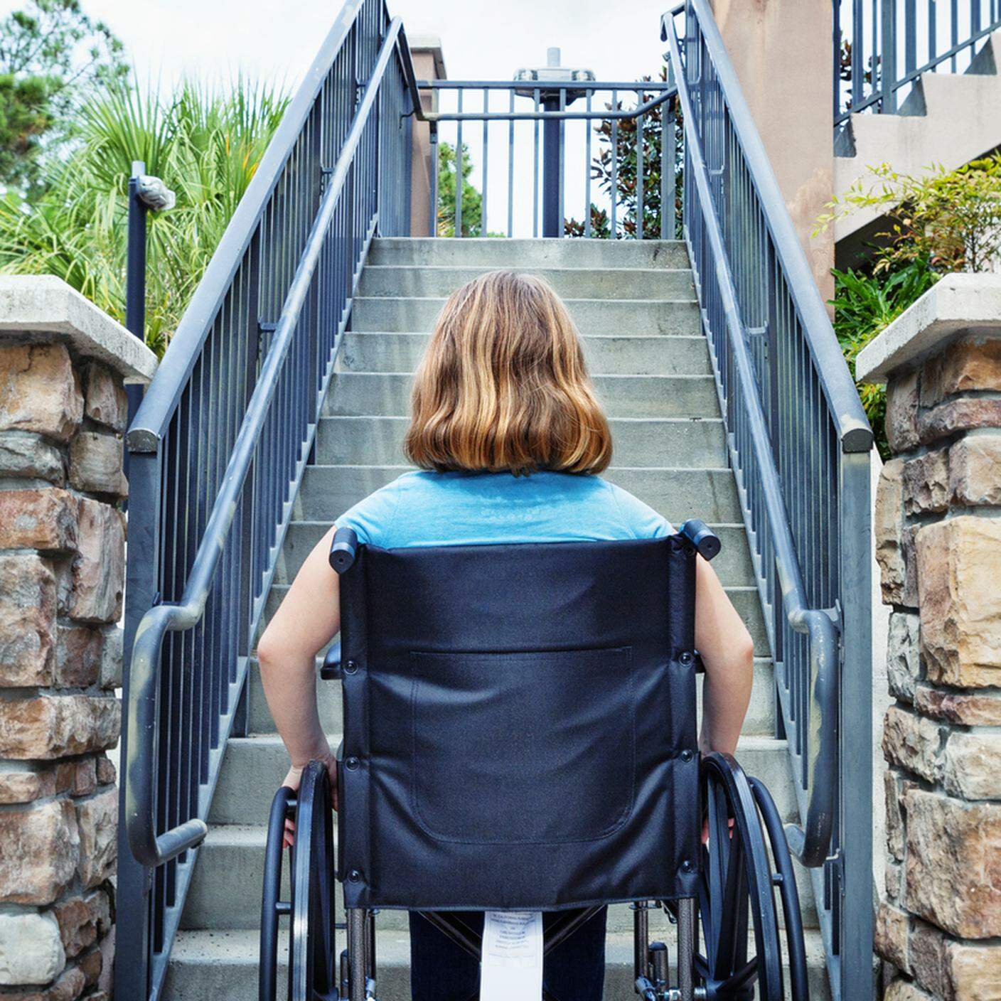 Disabilitato ragazza in sedia a rotelle alla fine delle scale