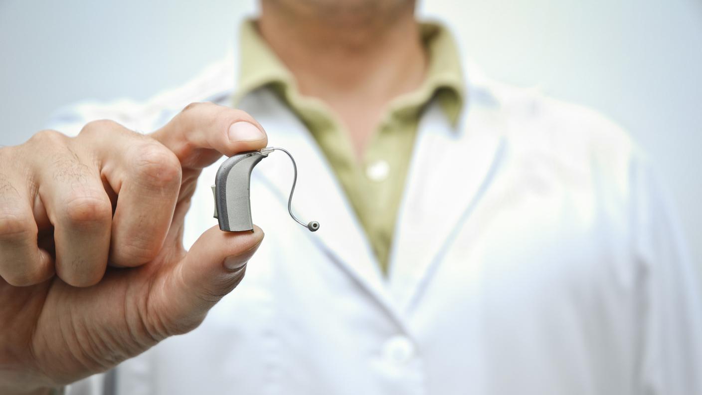 Medico mostrando Apparecchio acustico