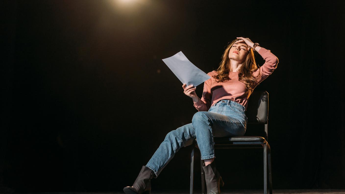 attrice recita scena drammatica a teatro, prove