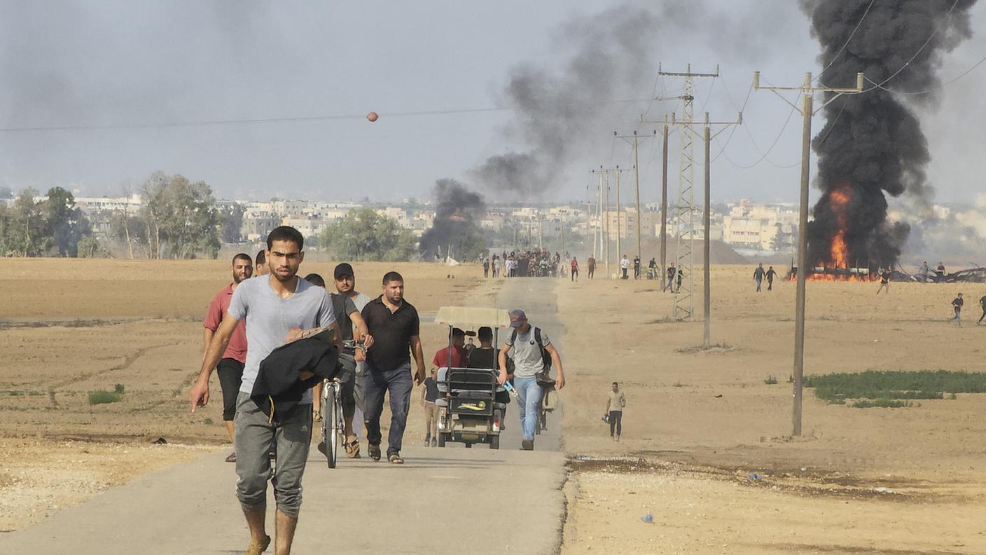 Palestinesi in fuga dal kibbutz di Kfar Azza, in Israele, vicino alla Striscia di Gaza