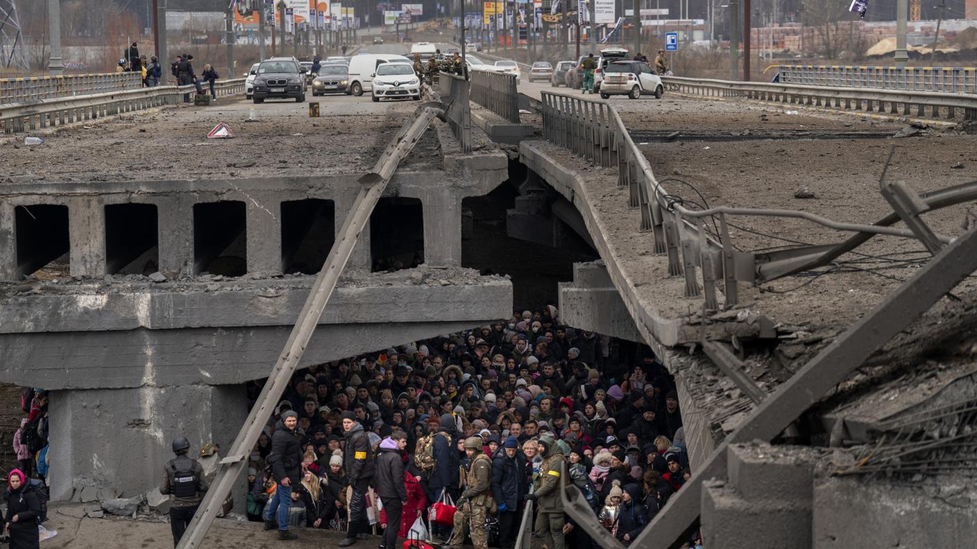 Ucraini accalcati sotto un ponte distrutto mentre cercano di fuggire attraversando il fiume Irpin alla periferia di Kiev