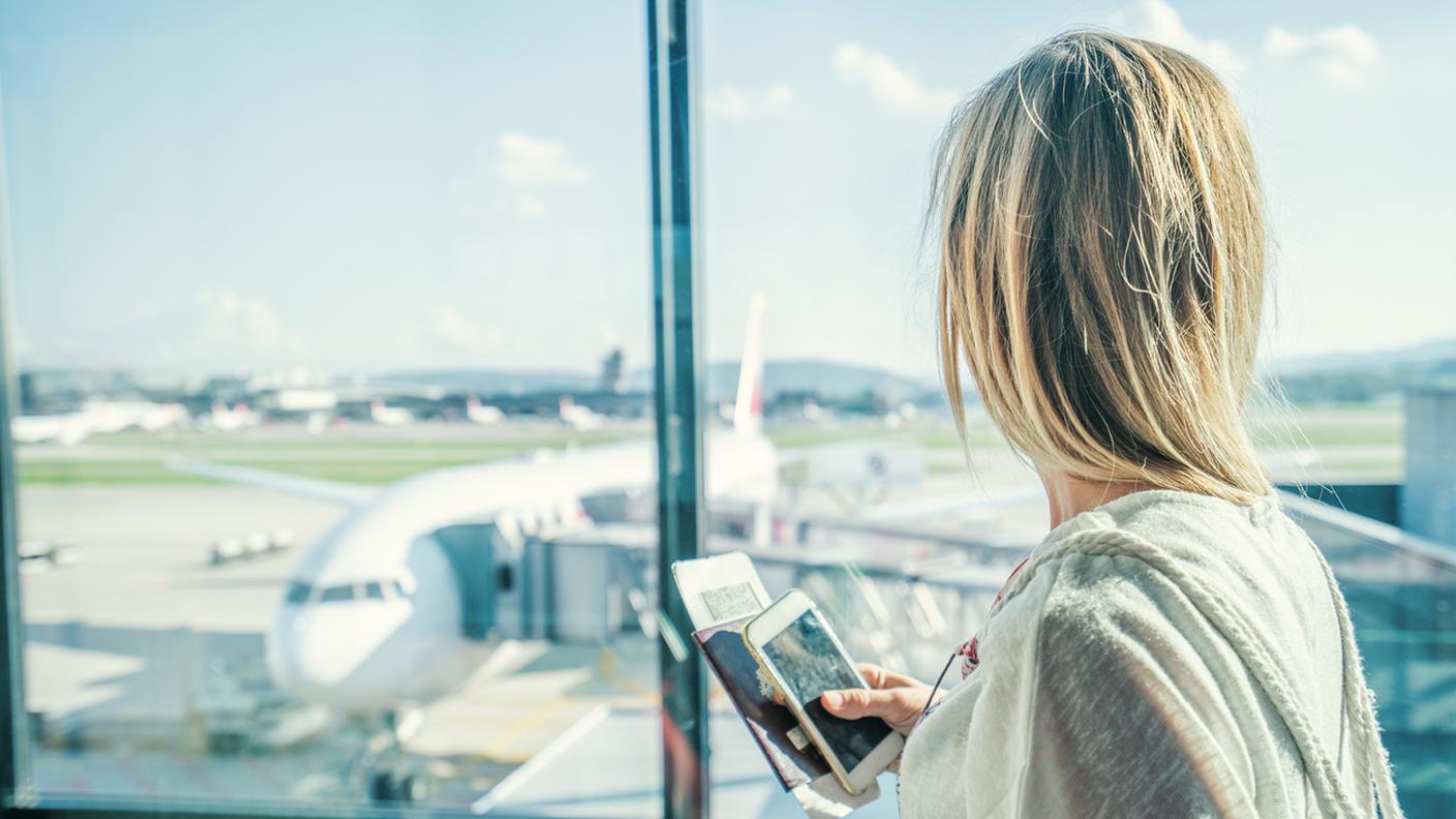 Donna all'aeroporto in terminal in attesa del volo di partenza