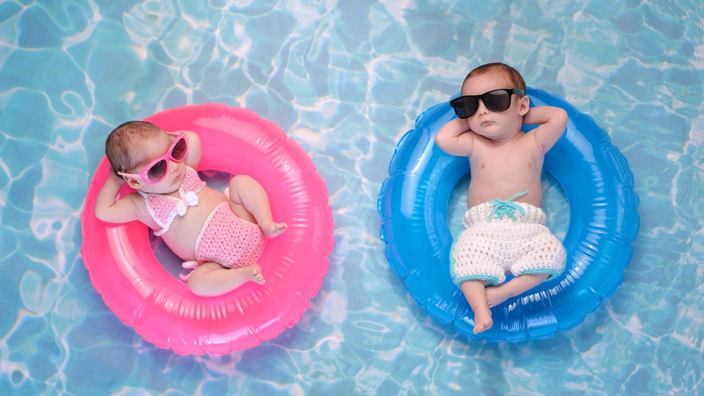 Baby femmina e maschio, galleggianti su anelli da bagno, gender
