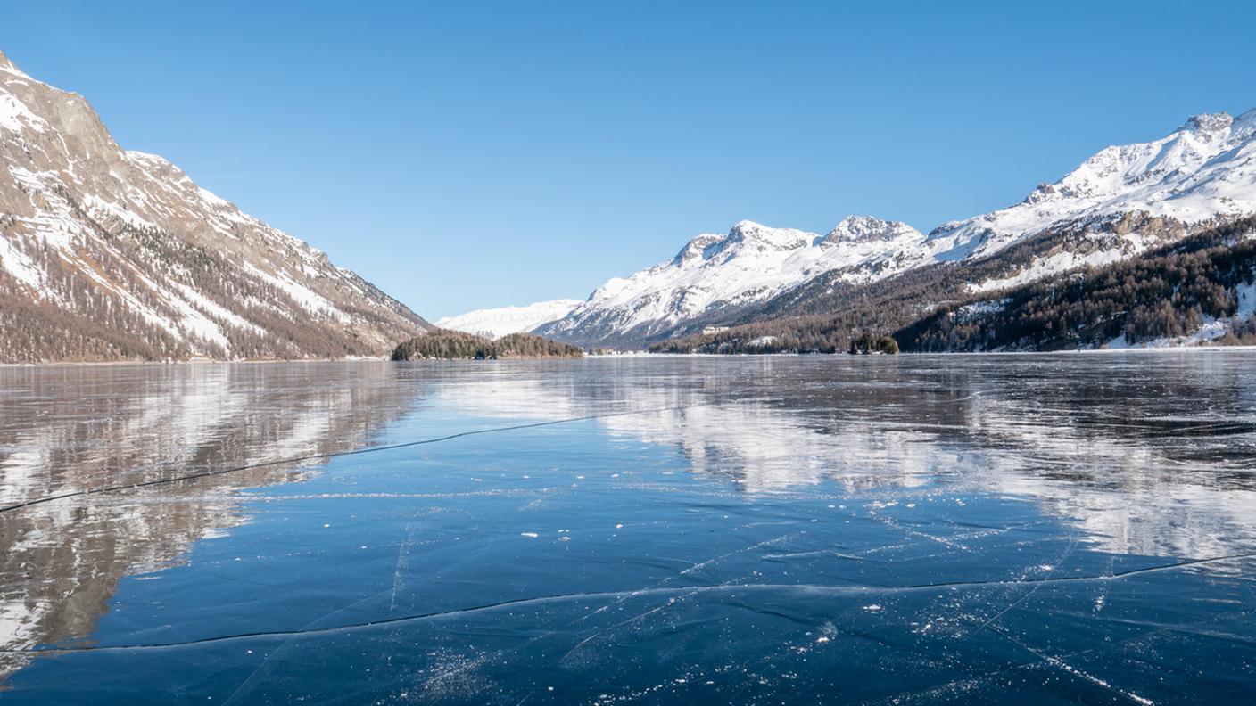 Lago ghiacciato e montagna innevata in Svizzera