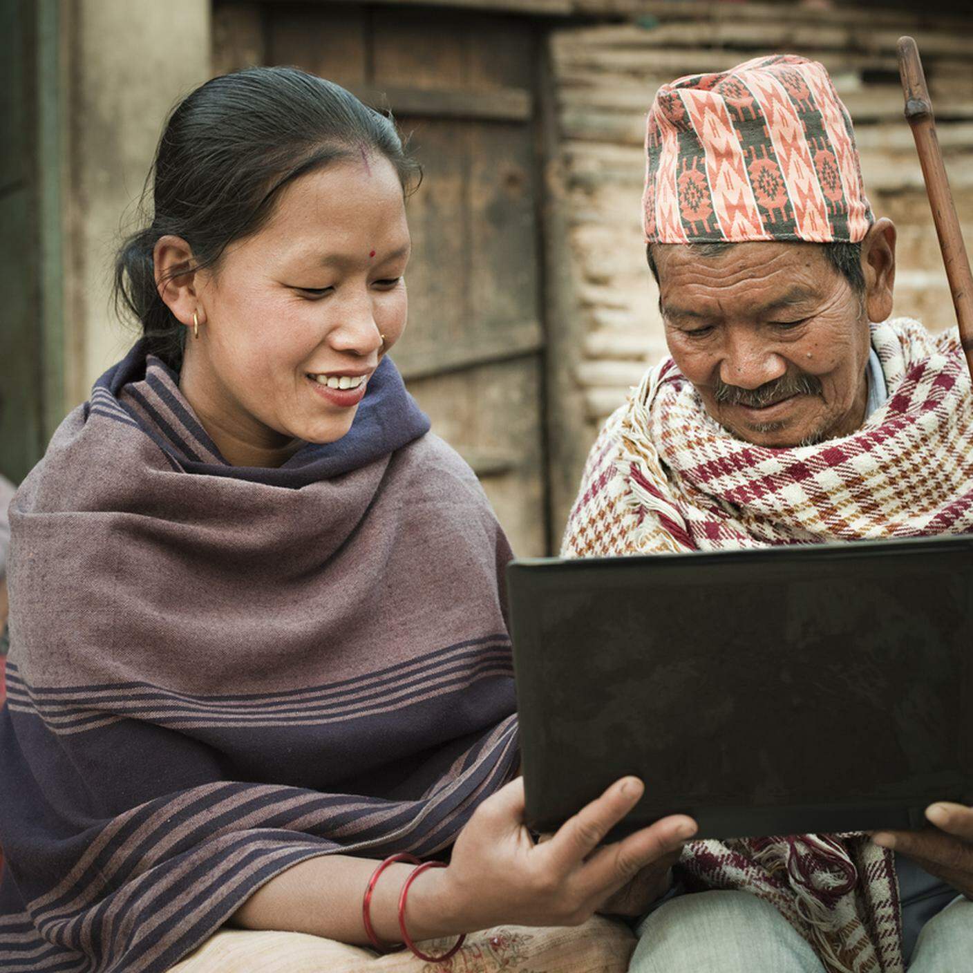 Nepa, giovane donna mostrando computer portatile di un uomo anziano