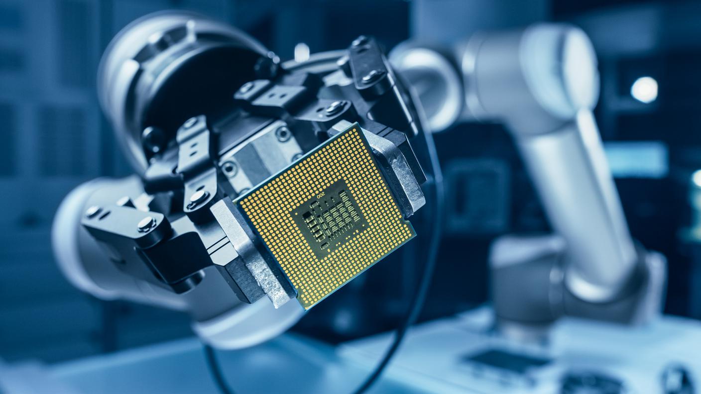 Braccio robotico autentico high-tech che tiene contemporaneo super processore per computer.