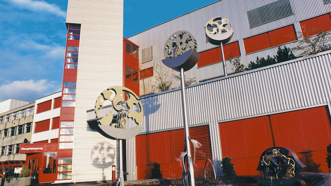 La fabbrica di Rivella con una fontana dello scultore in ferro Heiko Schuetzm, un regalo delle collaboratrici e dai collaboratori di Rivella per il 75° compleanno di Robert Barth