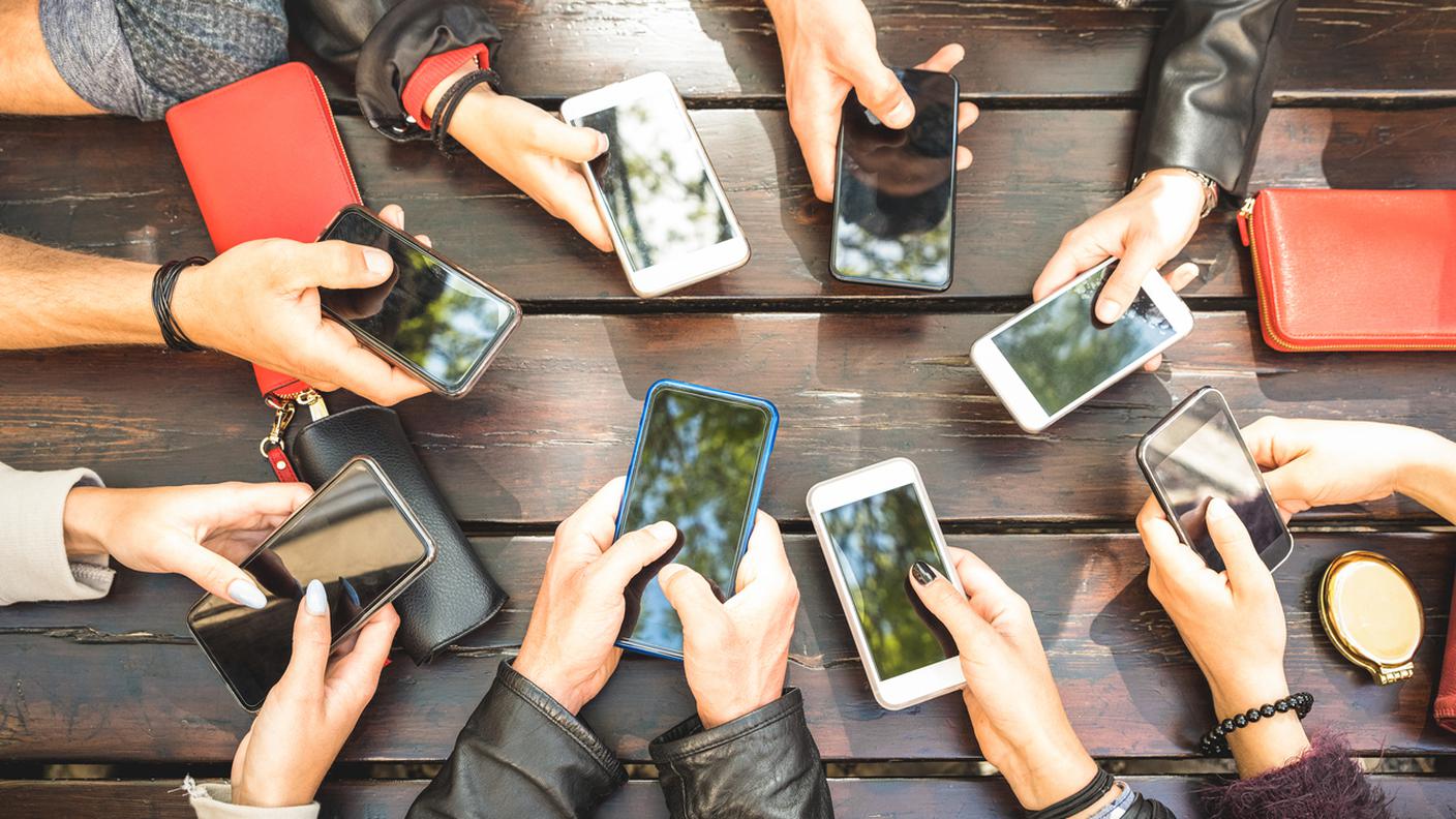 Giovani, millennial online che si divertono insieme usando gli smartphone