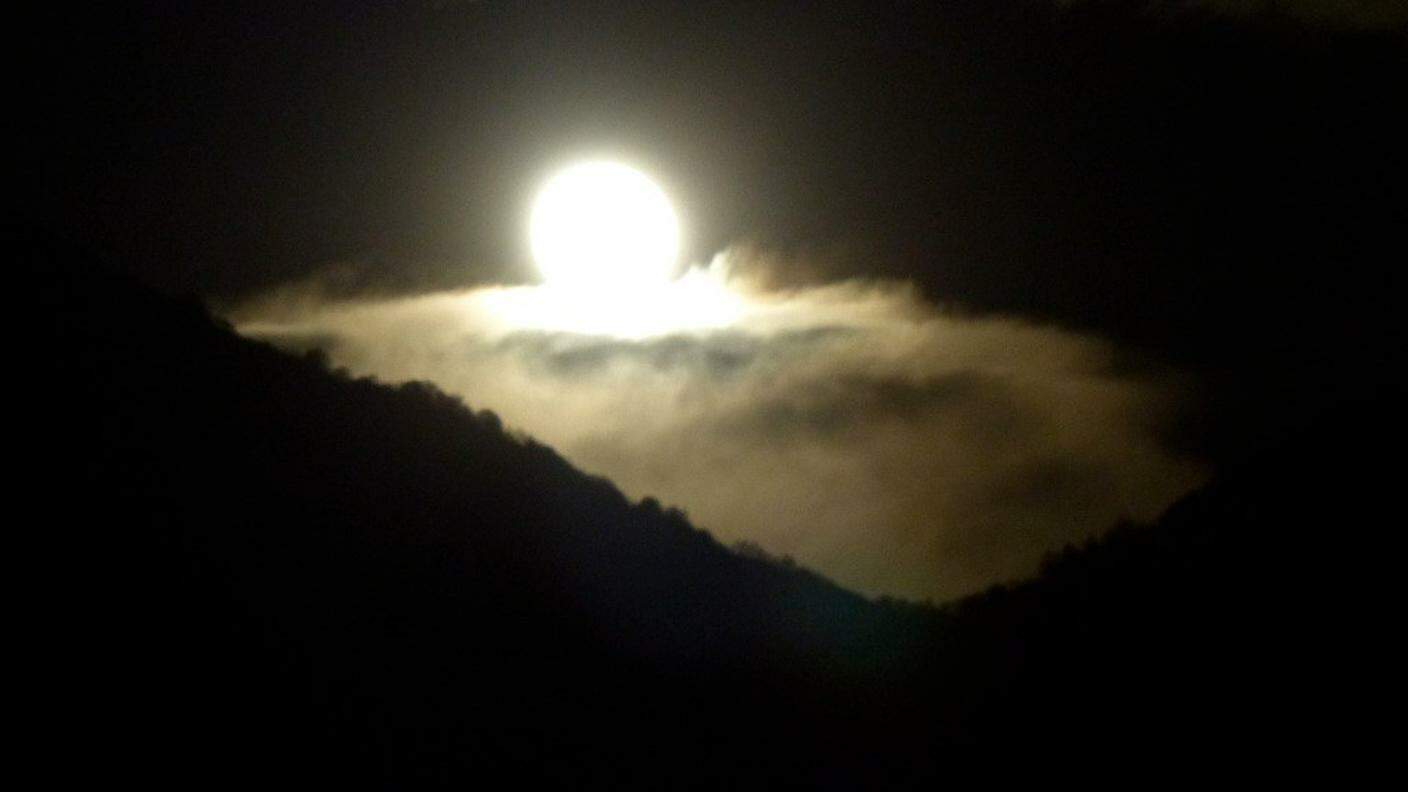 Luna su letto di nuvole, che spunta dietro il monte Boglia di Michela Mina