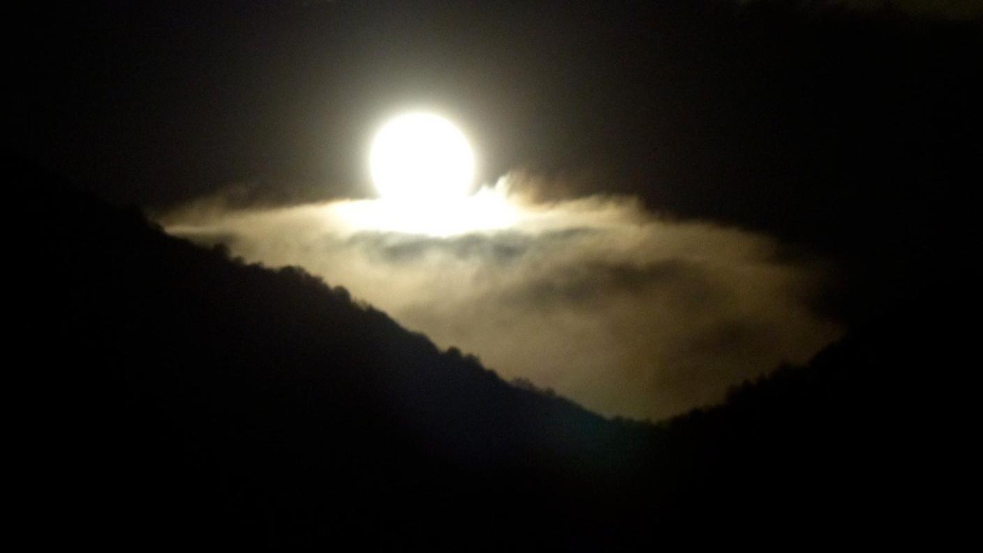 Luna su letto di nuvole, che spunta dietro il monte Boglia di Michela Mina