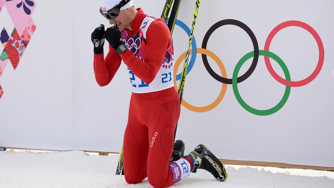 Dario Cologna in ginocchio davanti ai cinque cerchi