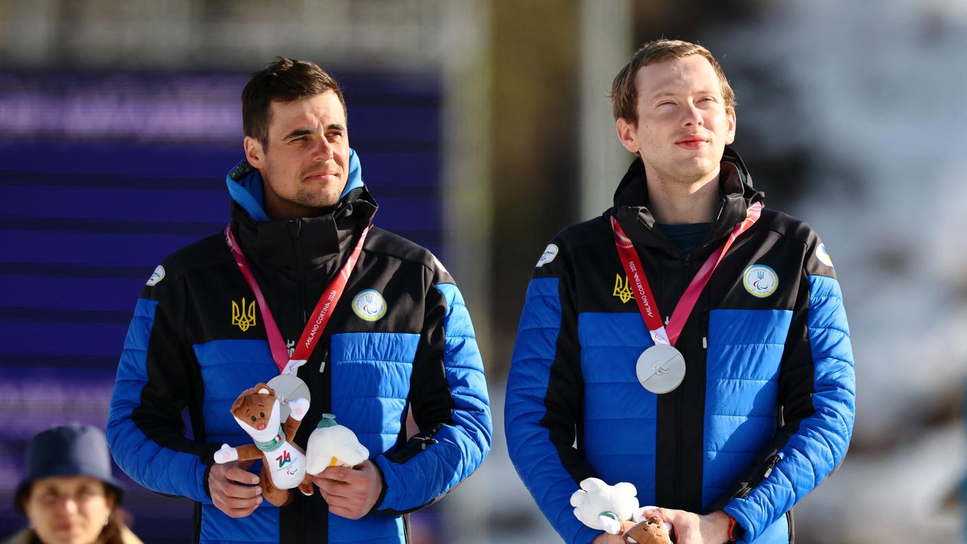 Il biatleta paralimpico ucraino sul podio di Milano Cortina 2026 insieme alla sua guida Vitaliy Trush